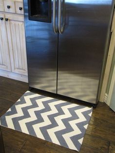 a large stainless steel refrigerator freezer sitting in a kitchen next to a white rug