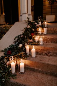 candles are lined up on the steps outside