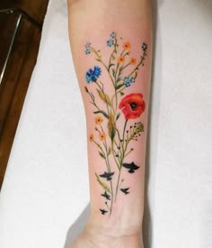 a woman's arm with flowers and birds on it