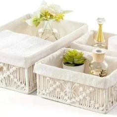 two white baskets with flowers and bottles in them