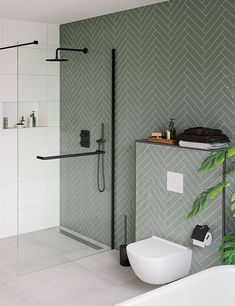 a bathroom with a tub, toilet and green wallpaper on the shower stall area