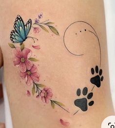 a woman's thigh with an animal paw and flower tattoo design on the side