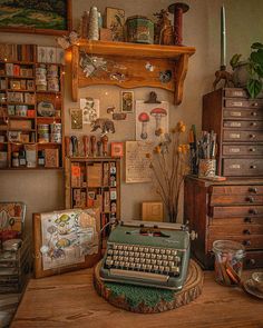 an old fashioned typewriter sitting on top of a wooden table next to other items