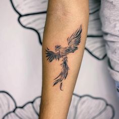 a black and white bird tattoo on the arm