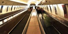 people are riding on an escalator in a subway