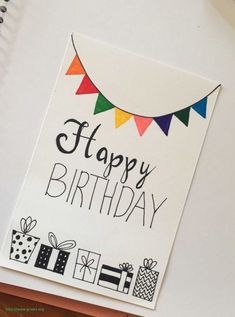 a happy birthday card on top of a desk next to a pen and laptop computer