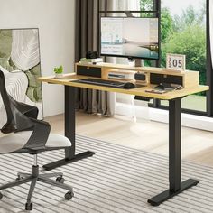 a computer desk with a monitor, keyboard and mouse on it in front of a window