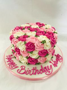 a birthday cake decorated with pink and white flowers