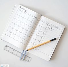 an open planner with a pencil and ruler next to it