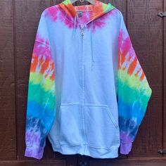 a tie dye hoodie hanging on a wooden door