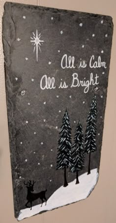 a slate sign that says all is calm, all is bright with deer and snowflakes on it