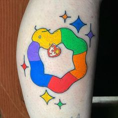 a person with a colorful tattoo on their leg that has an image of a snake in the shape of a rainbow