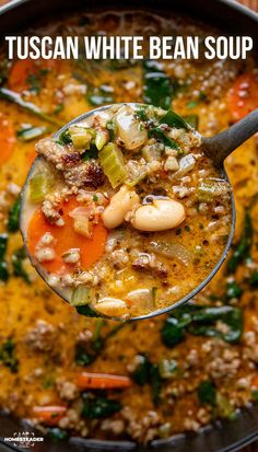 a spoon full of soup with beans, carrots and spinach in it that is being held up