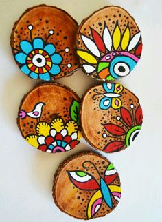 four wooden coasters with colorful designs on them