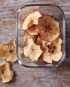 sliced apples in a glass container on a wooden table