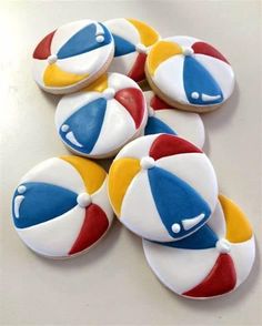 several decorated cookies are arranged on a table top with white and red, yellow and blue icing