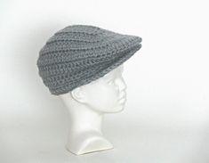 a white mannequin head wearing a gray knitted hat