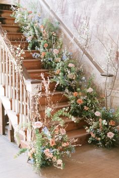 some flowers are growing on the stairs in front of a set of wooden banisters