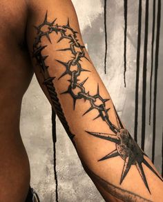 a man's arm is covered with barbed wire and has a star tattoo on it