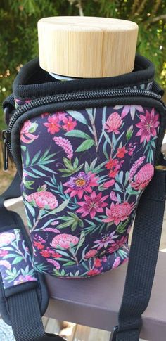 a black and pink flowered purse sitting on top of a bench