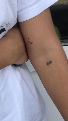 a person with a small tattoo on their arm and the word love written in cursive writing