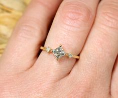 a woman's hand with a diamond ring on top of her finger and an engagement band