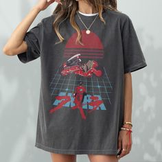 This vintage Akira inspired Anime t-shirt is perfect gift for anime fans and fans of 80s japanese films, this Akira graphic tee shirt pays homage to the iconic manga and animated masterpiece. This anime streetwear neo-tokyo akira shirt features a vintage-inspired graphic and pays homage to the dystopian world of Neo-Tokyo and the unforgettable characters, Kaneda and Tetsuo. The custom Akira-inspired t-shirt is a unisex fit for men and women and is also available in children's sizes (please messa 90s Anime Print Crew Neck T-shirt, 90s Anime Print Crew Neck Top, Retro Anime Print Tops For Streetwear, 90s Anime Print Short Sleeve T-shirt, Retro Anime Print Tops For Fan Merchandise, Retro Anime Print Tops For Fans, Retro Black Anime Print Tops, Black Retro Anime Print Top, Black Retro Top With Anime Print