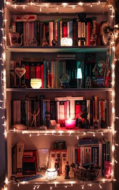 a bookshelf filled with lots of books covered in lights