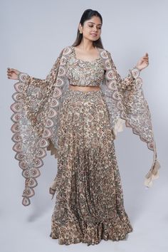 Beige sharara cape with multi colored floral prints and scalloped embroidered borders. Comes with matching printed skirt and embroidered blouse. - Aza Fashions Beige Sharara, Cape Skirt, Anamika Khanna, Jacket Cape, Printed Skirt, Sharara Set, Floral Print Blouses, Cut Work, Skirt Pattern