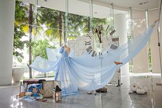 a large blue hammock in the middle of a room with clocks on it