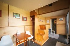 a room with wood paneling and white chairs, desks and pictures on the wall