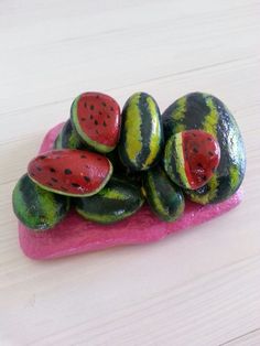 a pile of watermelon slices sitting on top of a pink rock