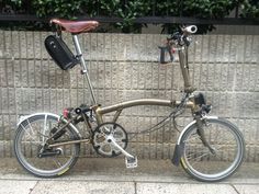 a bike parked next to a wall with a bag on the handlebars and seat