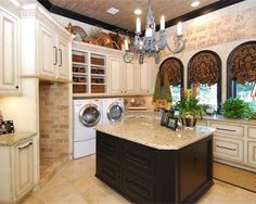 a large kitchen with white cabinets and marble counter tops