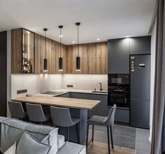 a modern kitchen and dining area with wooden cabinets, black appliances and gray chairs are featured in this image