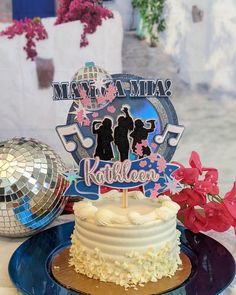 a cake on a blue plate with a mirror ball and flowers in the back ground