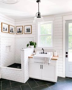 a white bathroom with black and white tile flooring