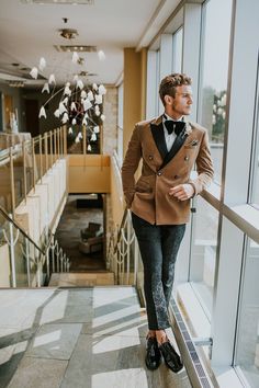 a man in a tuxedo is walking down the stairs