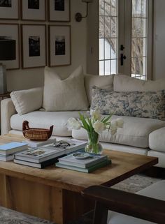 a living room filled with furniture and pictures on the wall next to a coffee table