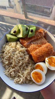 a white plate topped with rice, eggs and salmon