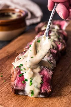 a person holding a fork with some kind of food on it's side,