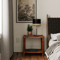 a bed room with a neatly made bed and a painting on the wall above it