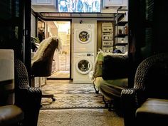 a washer and dryer are sitting in the doorway to a room with chairs