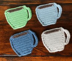 three crocheted mugs sitting on top of a wooden table