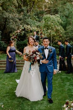 a bride and groom walking down the aisle at their outdoor wedding ceremony with guests in the background