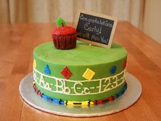 a green birthday cake with a cupcake on top