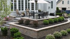 a patio with an umbrella and chairs around it