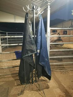 two umbrellas are hanging on a rack in an enclosure