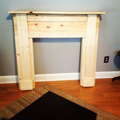 a wooden fireplace surround in the corner of a room