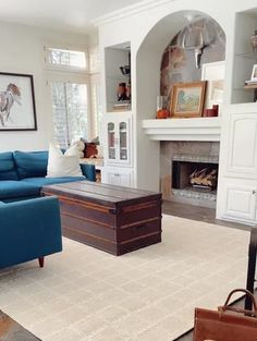 a living room filled with furniture and a fire place in the middle of the room